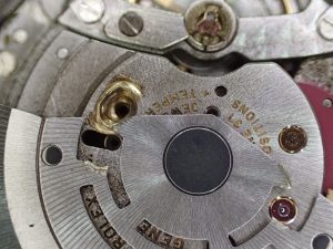 自動巻き機構を留めている2本のネジのうち、片方が外れています。